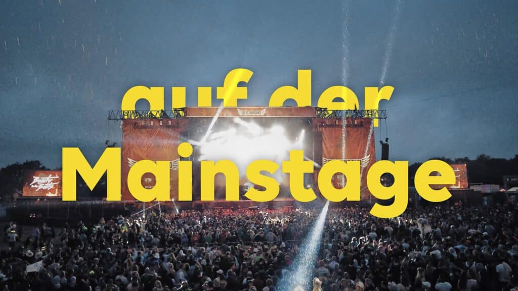 Festivalpublikum vor großer Bühne mit gelber Typografie „...auf der Mainstage“.